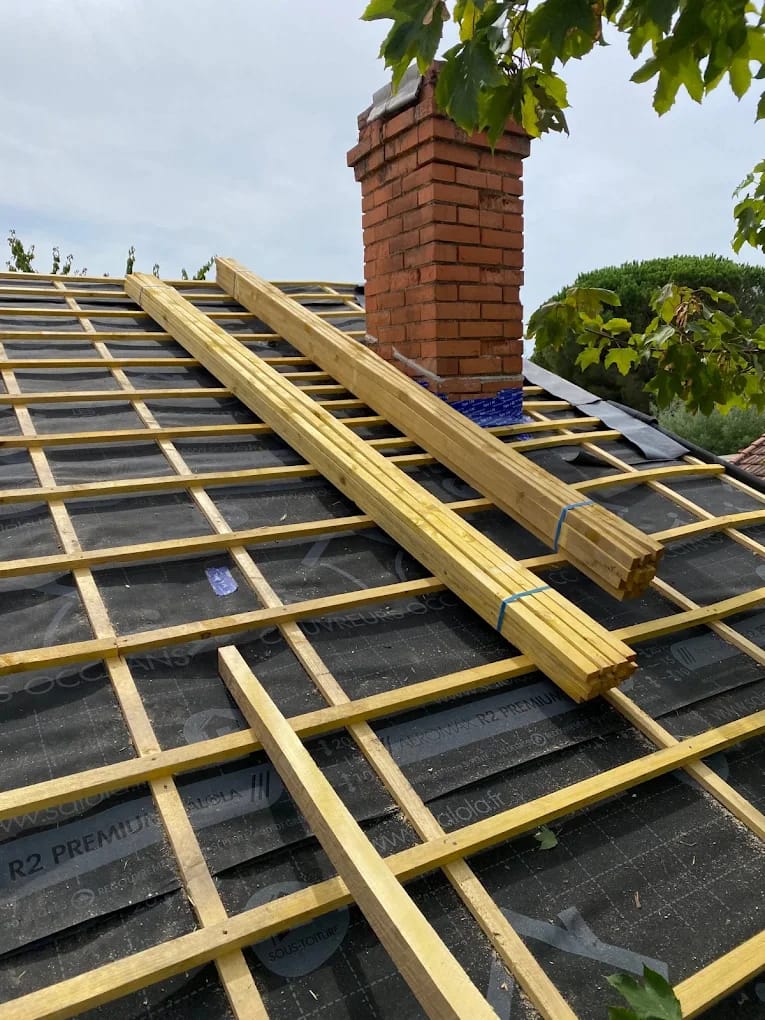 Préparation de charpente autour d'une cheminée pour tuiles à Perpignan