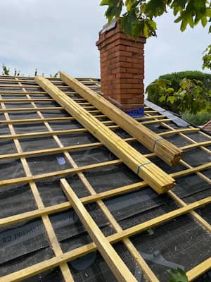 Préparation de charpente autour d'une cheminée pour tuiles à Perpignan